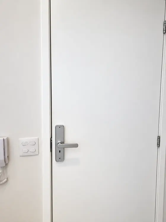 Fechadura digital prata com maçaneta em porta branca