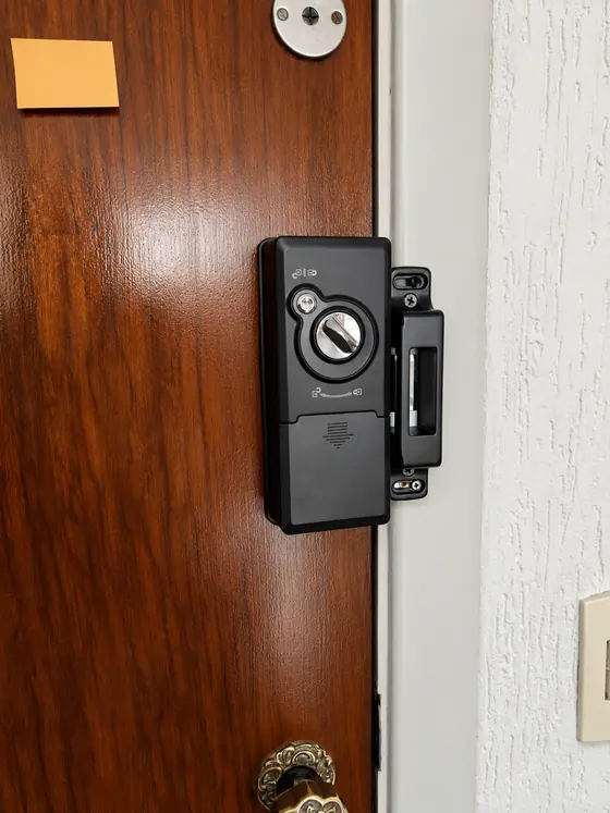 Fechadura digital de sobrepor preta em porta de madeira envernizada