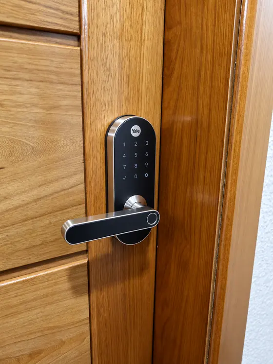Fechadura digital Yale com maçaneta preta e inox em porta de madeira